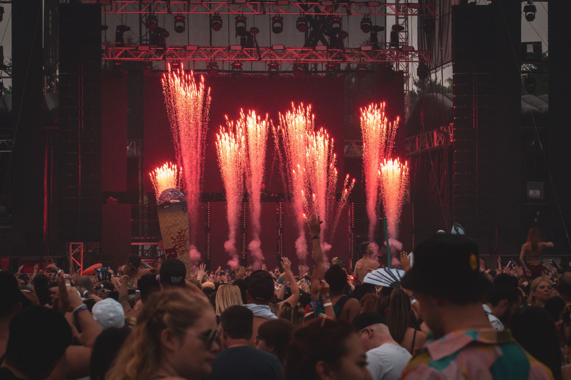 Lively music concert with a crowd and stunning fireworks lighting up the stage.