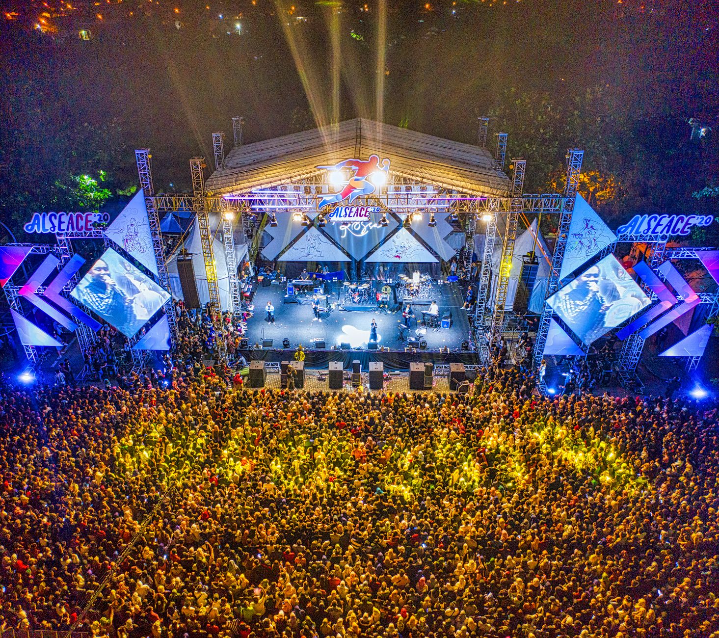 Aerial view of a large crowd enjoying a nighttime concert.